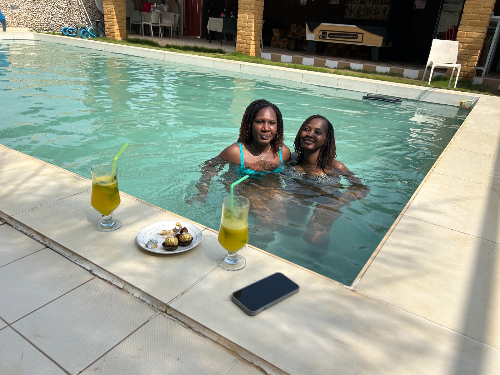 Moment de détente dans la piscine, cocktail à la main